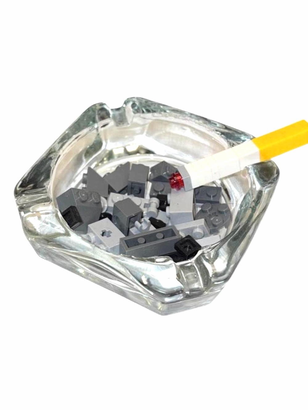 Clear Glass Ashtray Filled with Lego Ashes and Cigarette